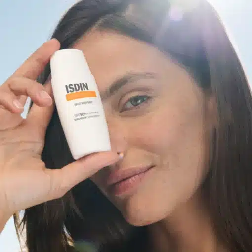 Femme montrant le flacon de Isdin FotoUltra 100 Spot Prevent SPF 50+